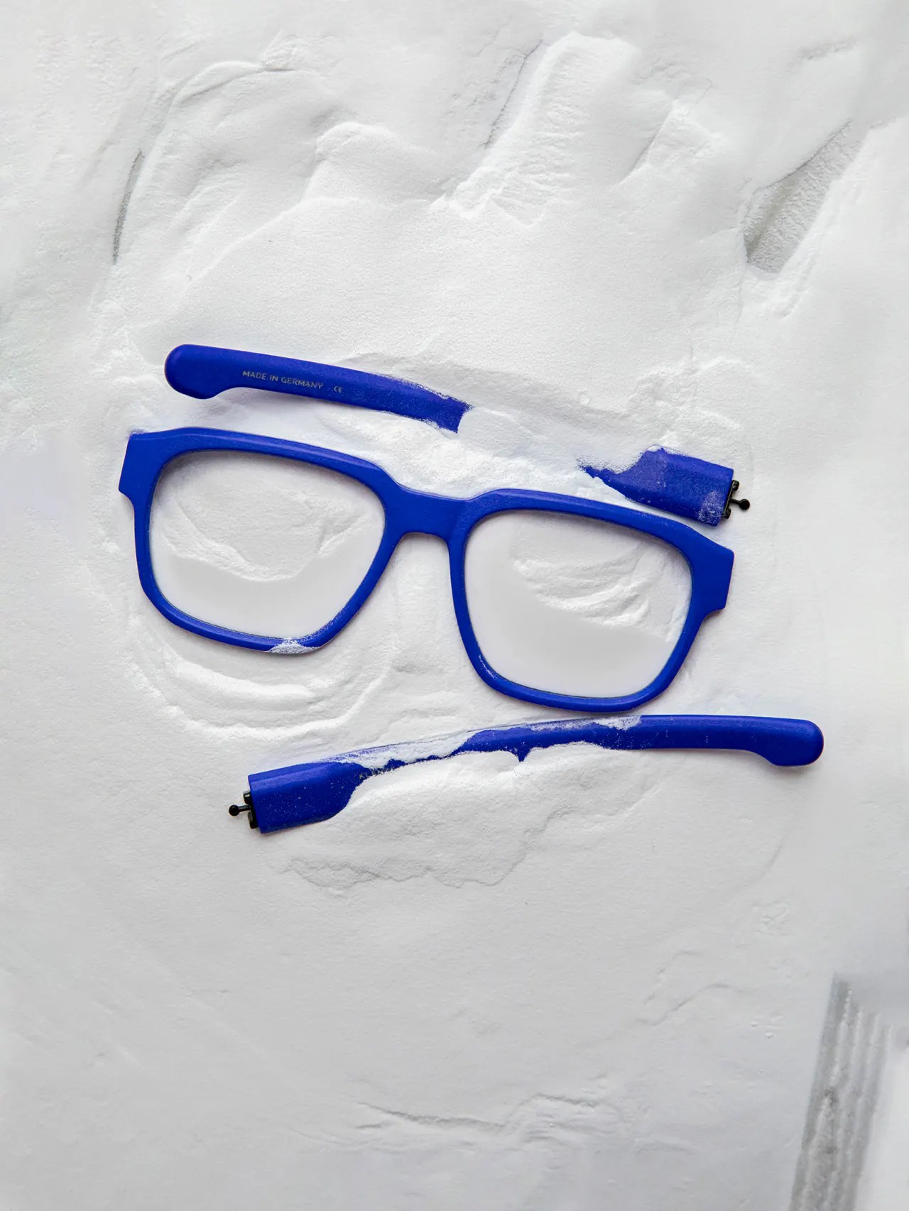 Fabrication d’une monture : façade et branches bleues sorties de la poudre d’impression 3D
