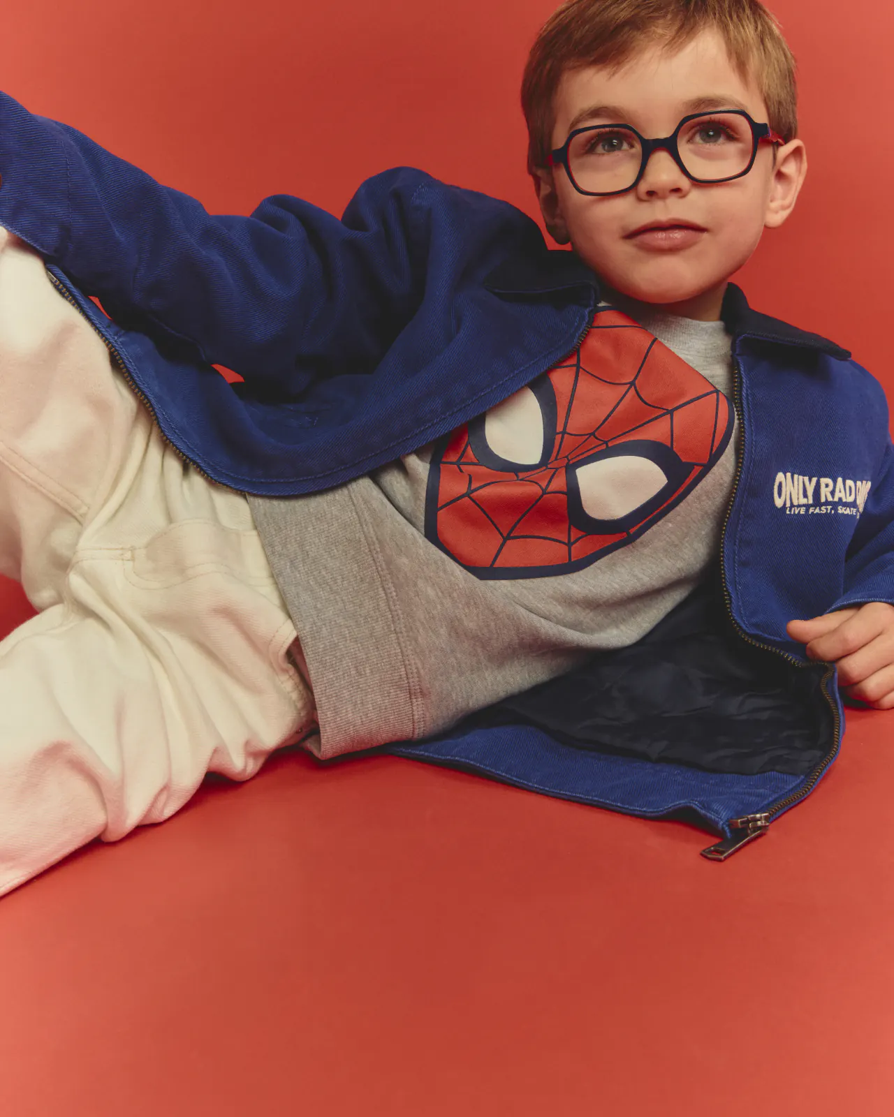 Jeune enfant portant des lunettes rondes et un pull Spider-Man, collection enfant Opal
