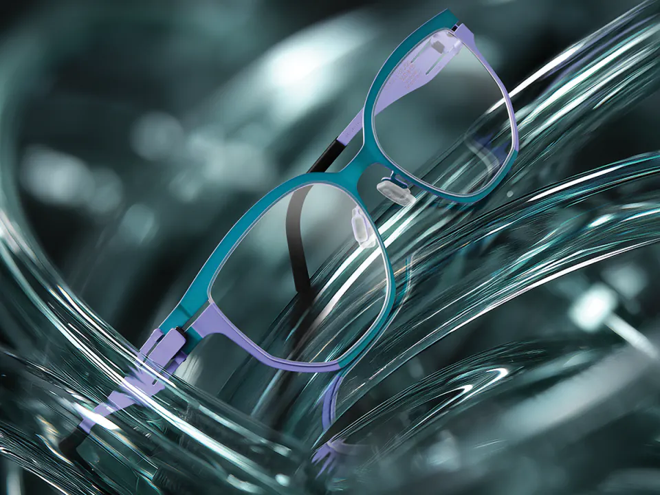 OVVO Optics — monture en acier et titane sur un fond de verre bleu-vert